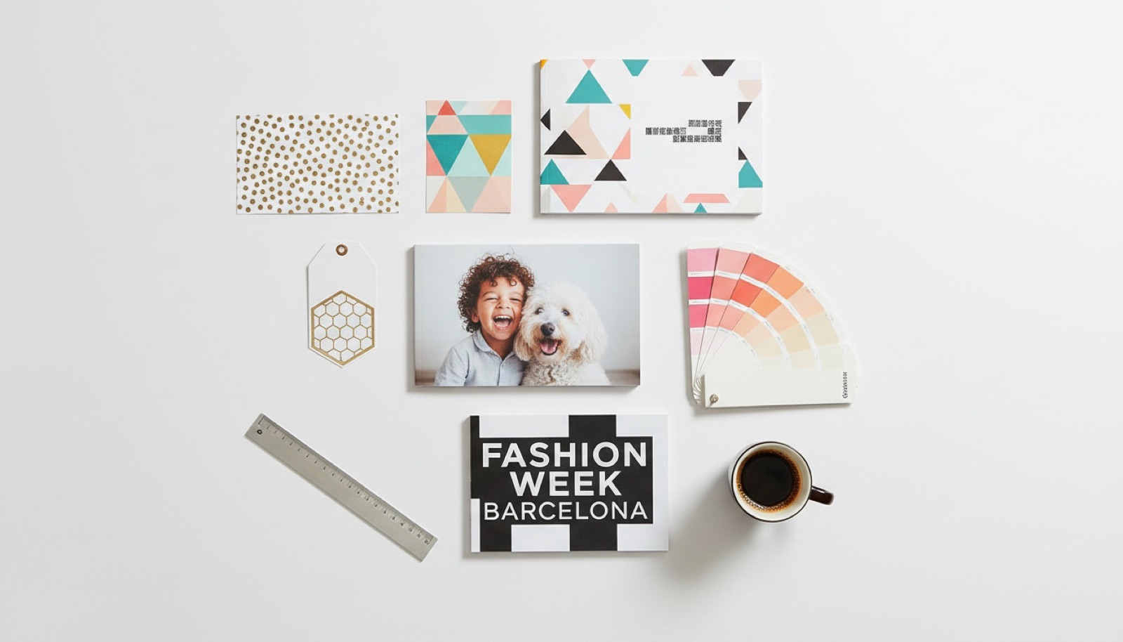Top-down flat-lay of mixed printed products: glitter cards, geometric patterns, foil tags, photo cards, color swatches, paper booklets, and a Fashion Week Barcelona 2015 poster