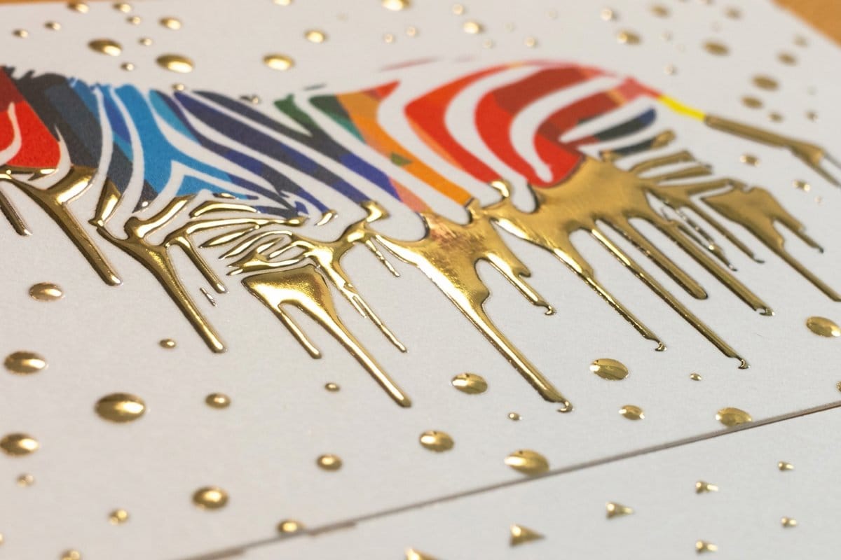 Raised gold foil print by 4OVER4 showing how a raised finish stands off the sheet