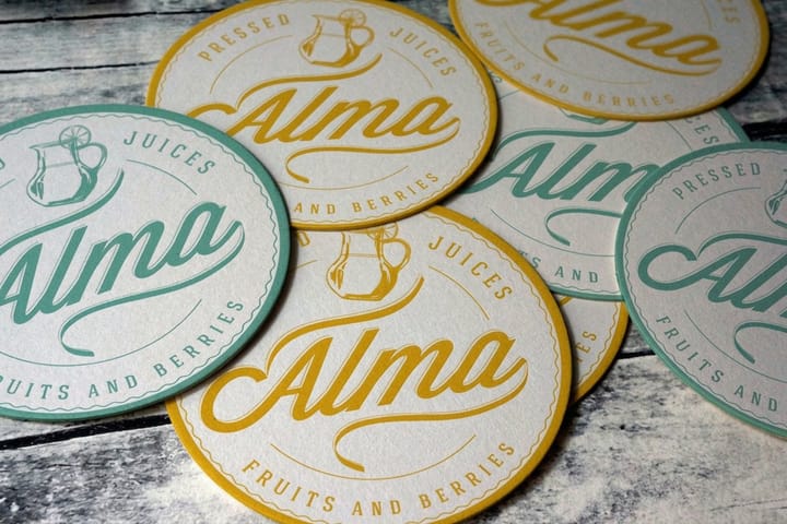 Custom drink coasters printed by 4OVER4 on a cafe table