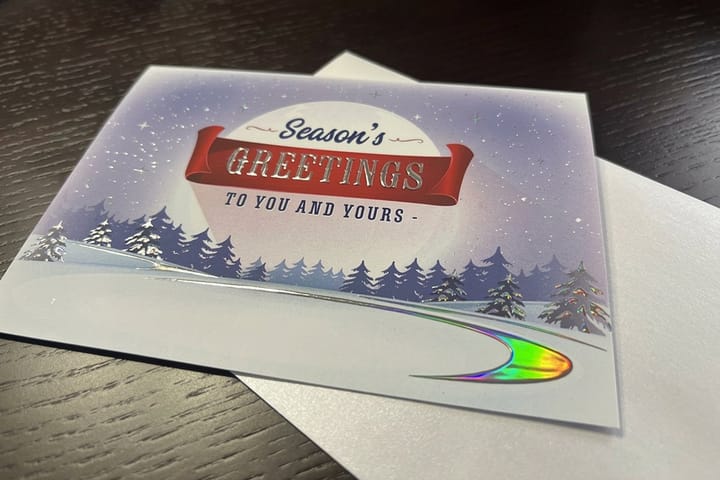 Raised holographic greeting cards printed by 4OVER4 standing open on a desk