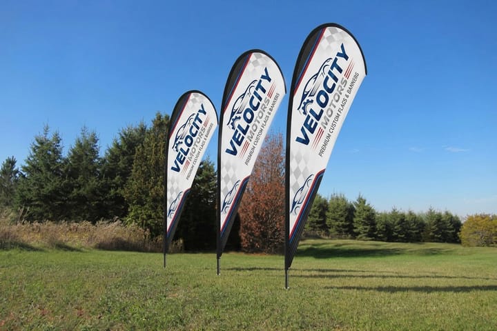 Automotive feather flags from 4OVER4 lining a dealership driveway