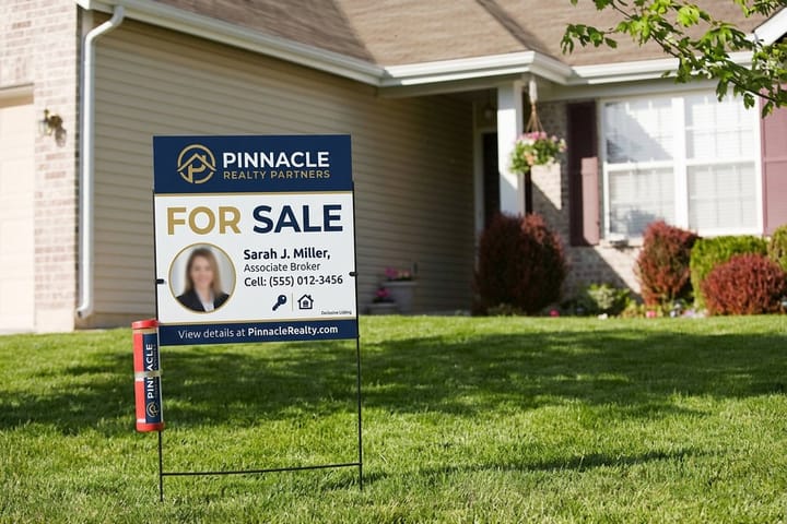 Real estate sign panel from 4OVER4 hanging in a post frame at a listing