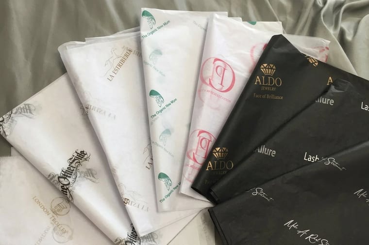 Custom branded food wrapping and tissue paper around a takeout item, printed by 4OVER4