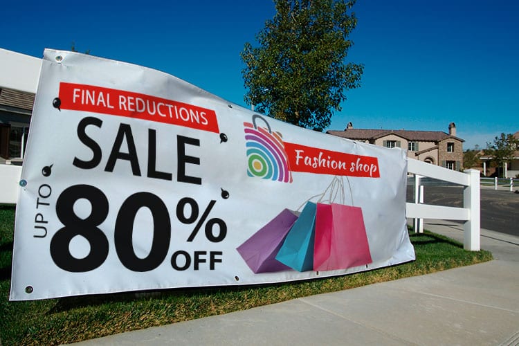 A large vinyl banner hung across a storefront, printed by 4OVER4