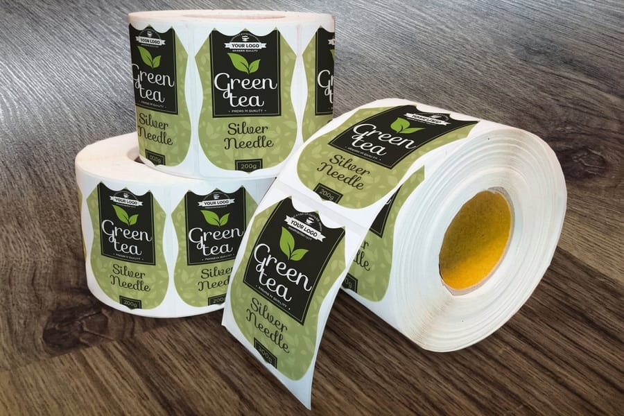 Shaped roll labels printed by 4OVER4 wound on a roll with the die-cut outline visible