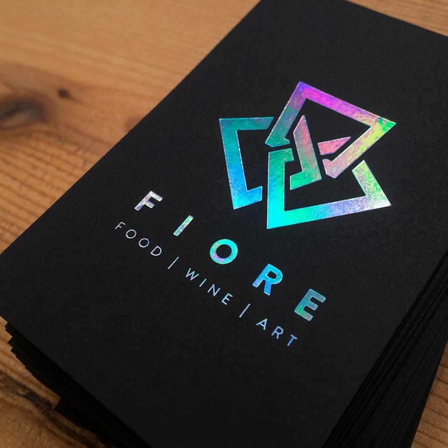 Holographic business card printed by 4OVER4 showing a brand logo catching the light