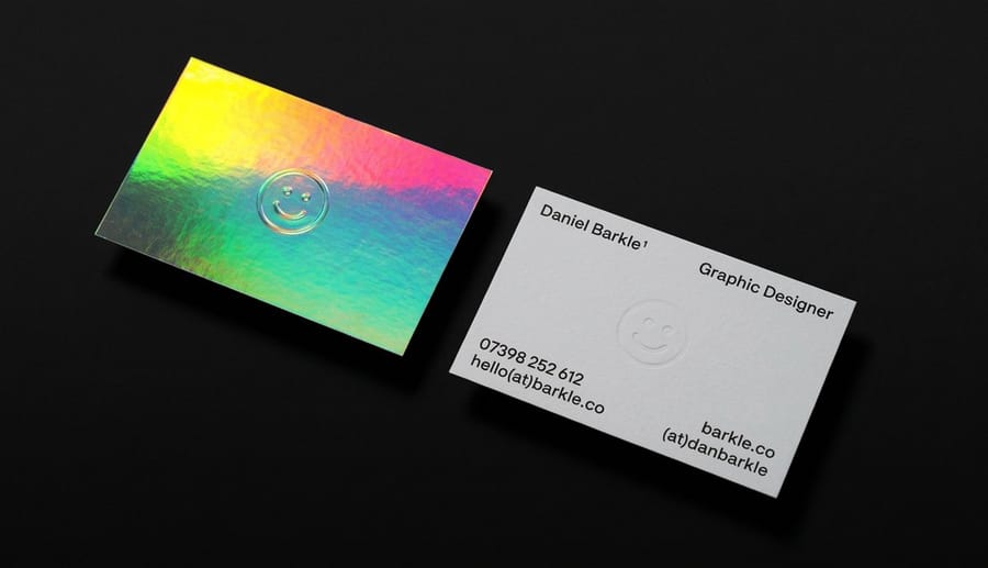 Finished holographic business cards from 4OVER4 fanned out to show the logo