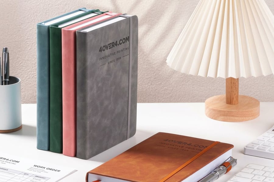 Leather journals printed by 4OVER4 stacked and ready for corporate gifting