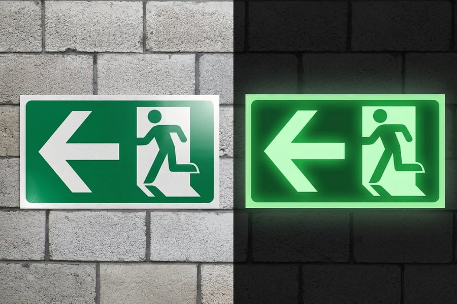 Reflective aluminum sign printed by 4OVER4 photographed at night under vehicle headlights