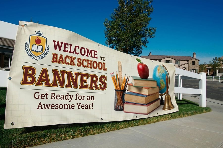 Welcome back to school banner from 4OVER4 with a crest, bold headline and strong contrast on a fence