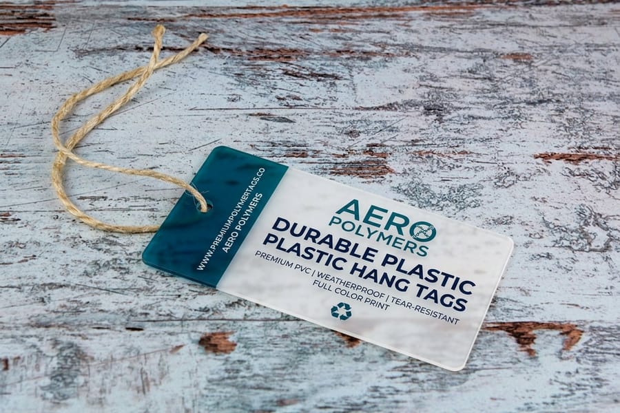 Plastic hang tags from 4OVER4 showing edge-to-edge printing and a drilled strap hole