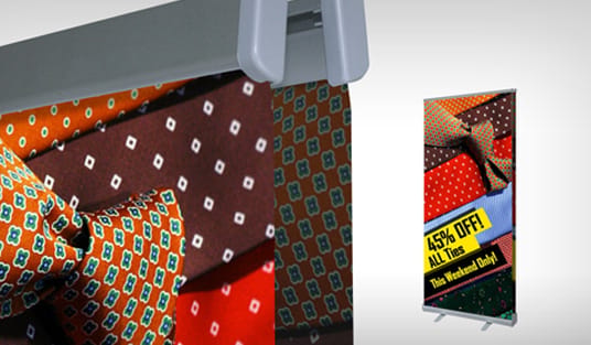 Large banner sized to its display space at a trade show, printed by 4OVER4