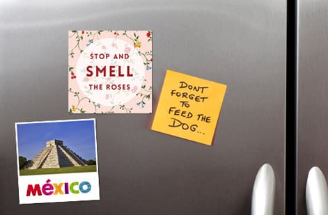 Fridge magnets at several sizes compared on a refrigerator door, printed by 4OVER4