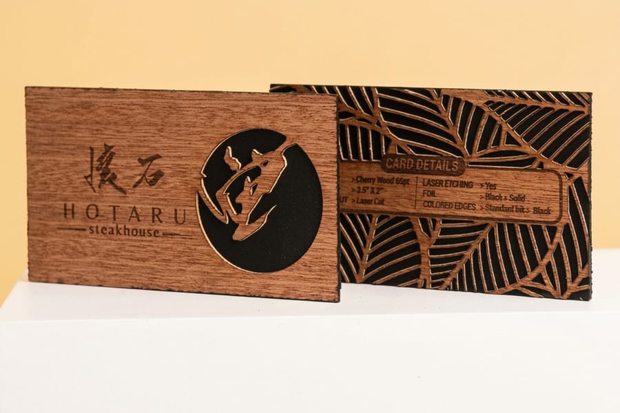 A wood veneer business card showing natural grain and printed ink from 4OVER4