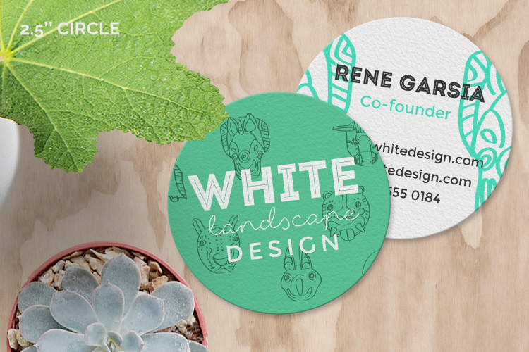 Custom-printed 2.5-inch circular business cards on textured paper for a modern landscaping brand.